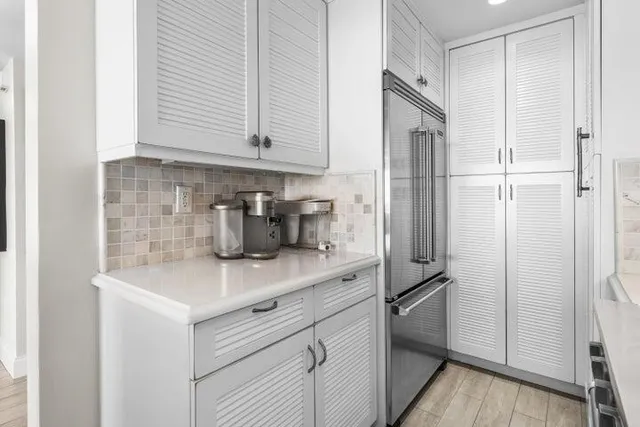 a kitchen with stainless steel appliances white cabinets and a refrigerator