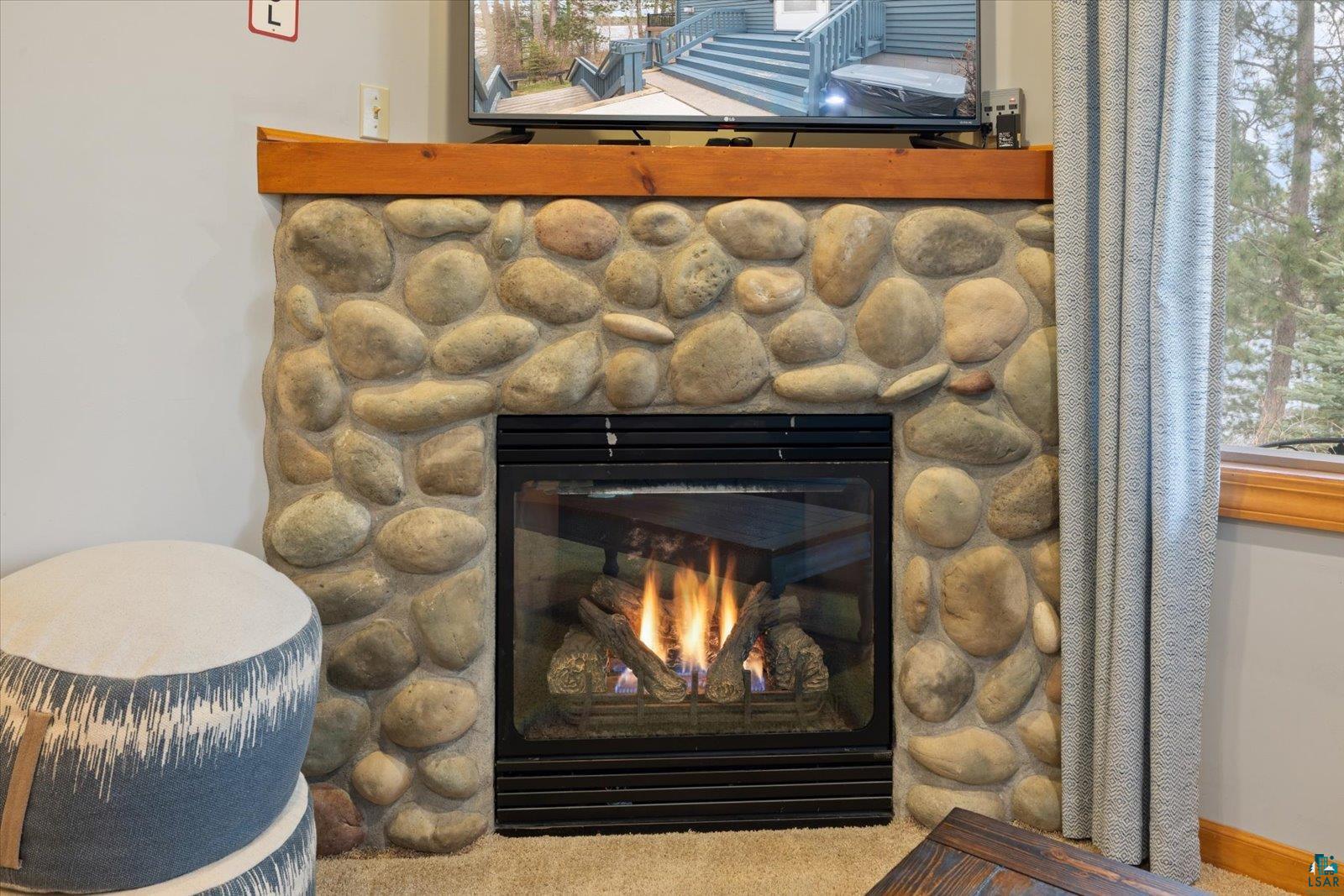 6266 Giants Ridge Road Biwabik, MN 55705 - Photo 33 of 37 River rock fireplace with a wood mantel