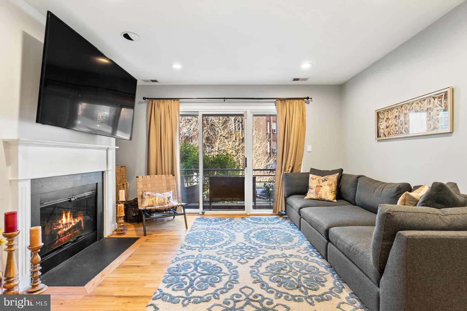 1710 Summit Place Northwest, Unit 1710 Washington, DC 20009 - Photo 11 of 35 a living room with furniture tv and a fireplace