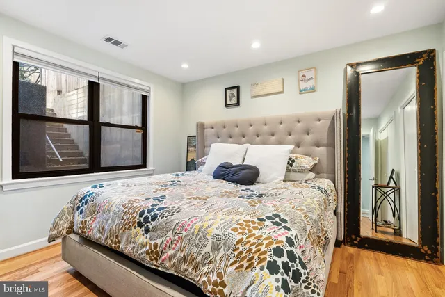 a large bed sitting in a bedroom next to a window