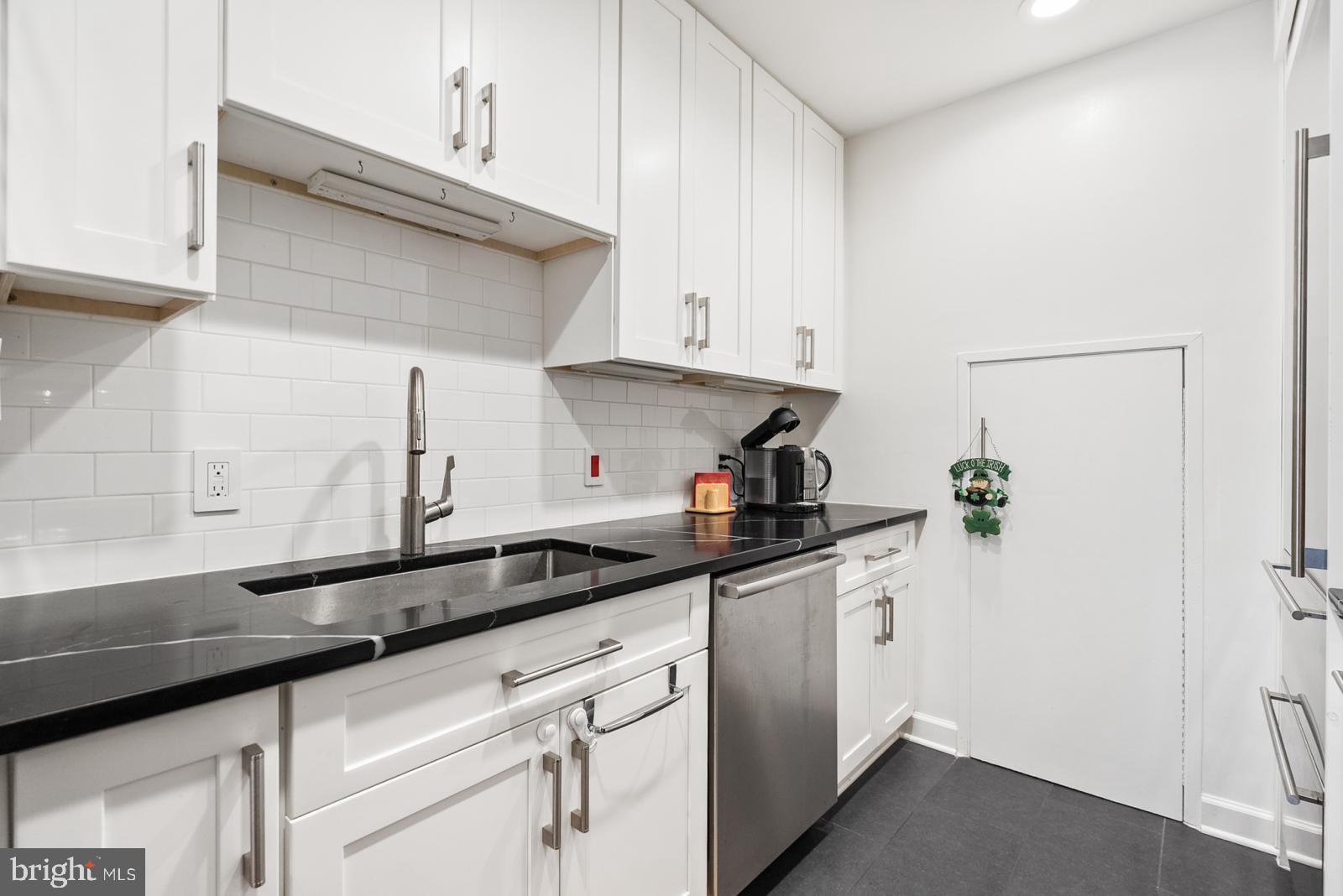 1710 Summit Place Northwest, Unit 1710 Washington, DC 20009 - Photo 3 of 35 a kitchen with granite countertop a sink and cabinets