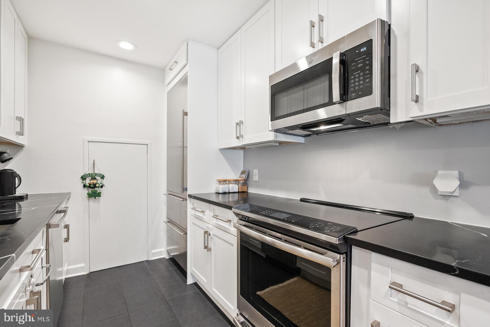 1710 Summit Place Northwest, Unit 1710 Washington, DC 20009 - Photo 4 of 35 a kitchen with stainless steel appliances a stove microwave and sink