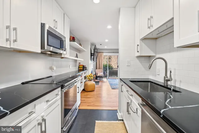 a kitchen with stainless steel appliances granite countertop a sink a stove and a microwave
