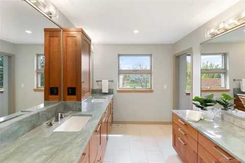a bathroom with a granite countertop sink and a mirror