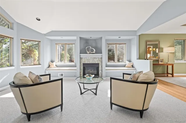 a living room with furniture a fireplace and a large window