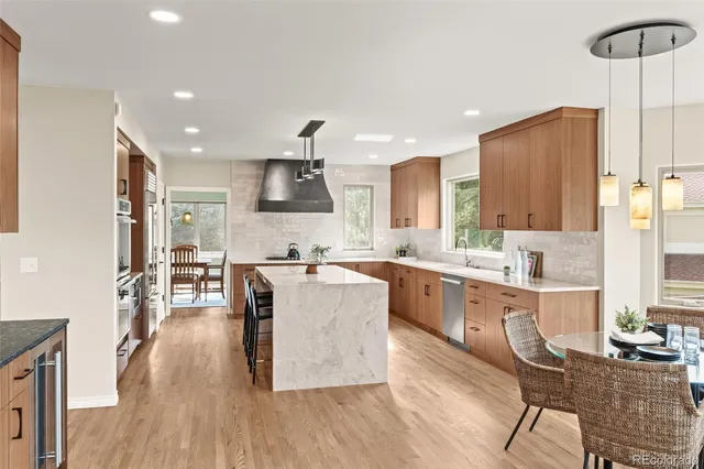 a large kitchen with stainless steel appliances kitchen island granite countertop a large center island and a stove top oven