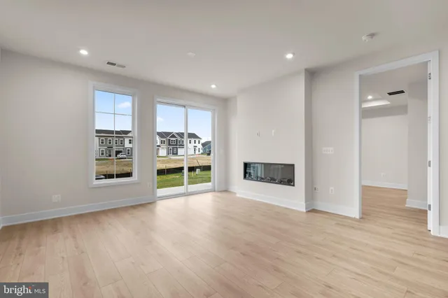 a view of a big room with wooden floor and windows