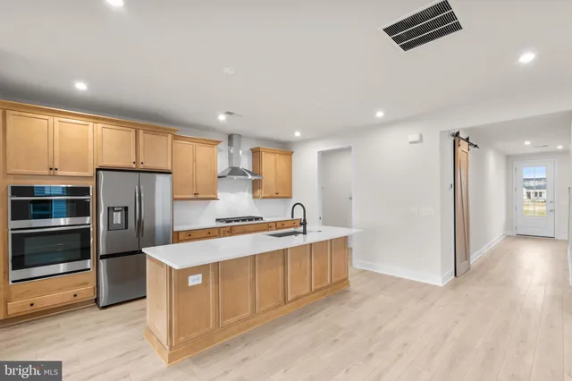 a kitchen with stainless steel appliances a refrigerator and a stove top oven