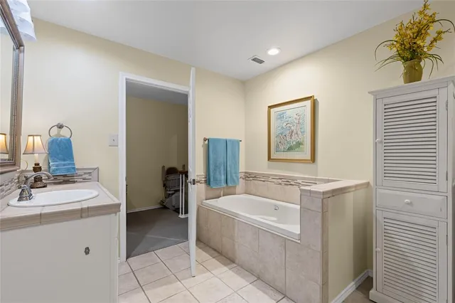 a bathroom with a tub sink and mirror