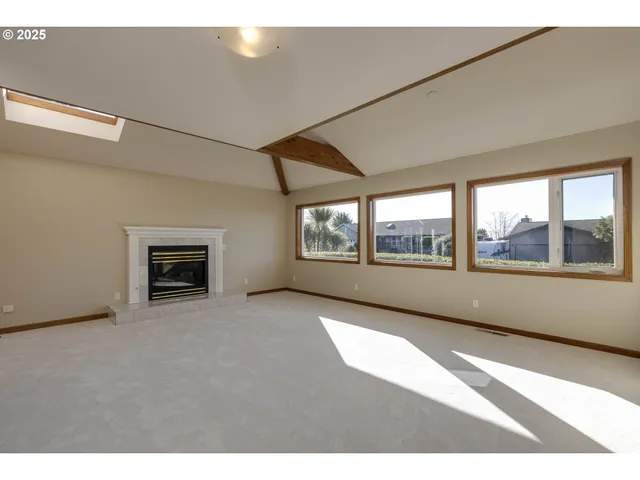 a view of an empty room with a window and fire place