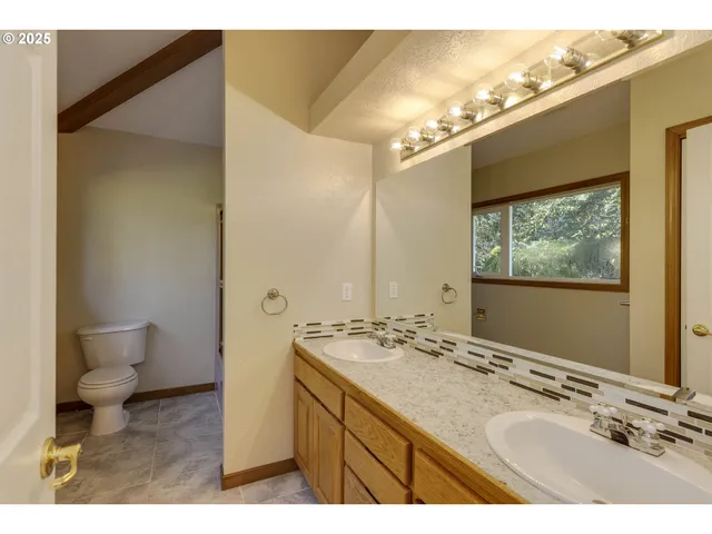 a bathroom with a sink mirror and a toilet