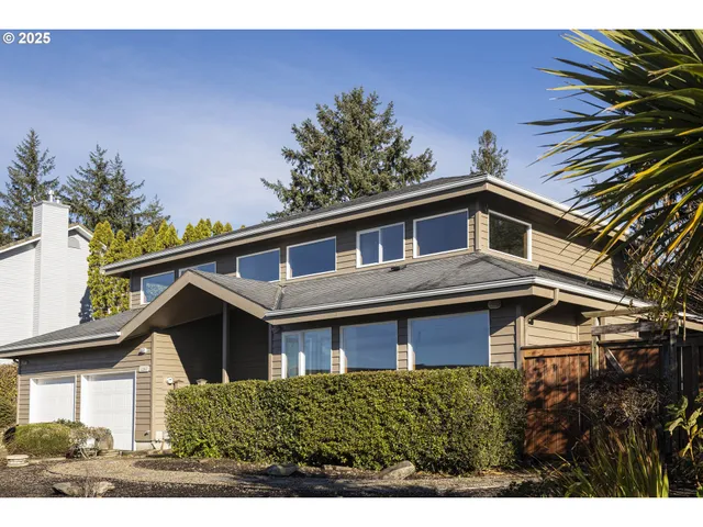 a house that has a lot of windows and trees in the background