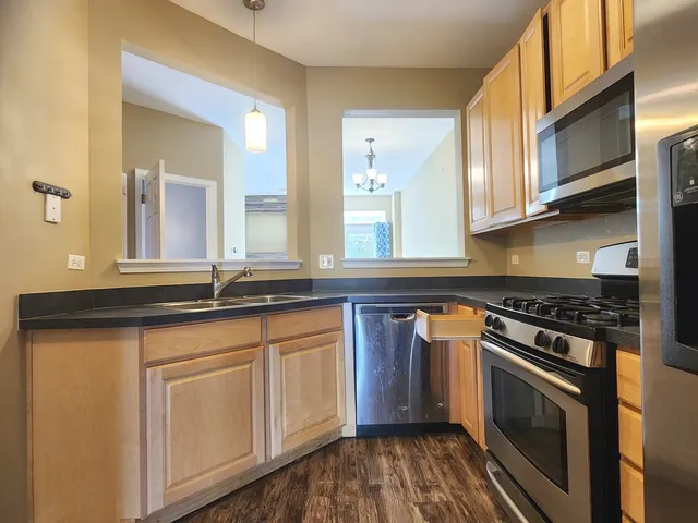 a kitchen with granite countertop a sink a stove and cabinets