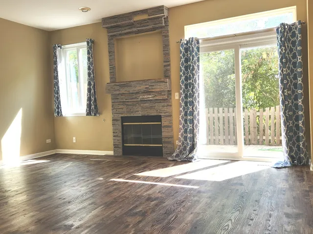 a view of empty room with wooden floor and fireplace