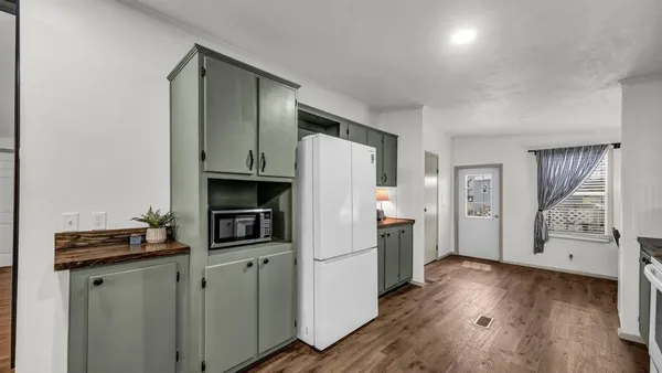 a kitchen with a refrigerator and a stove top oven