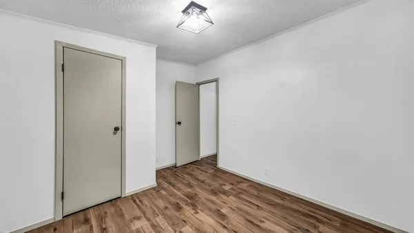 a view of a room with wooden floor and a ceiling fan
