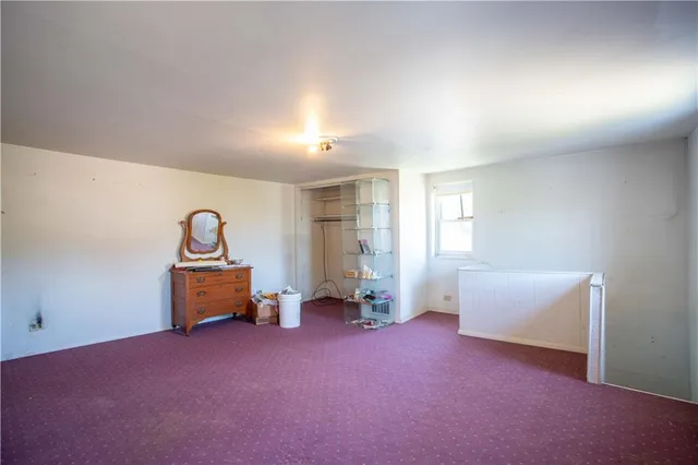 an empty room with windows and couch