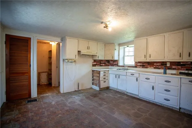 a kitchen with cabinets appliances and a window