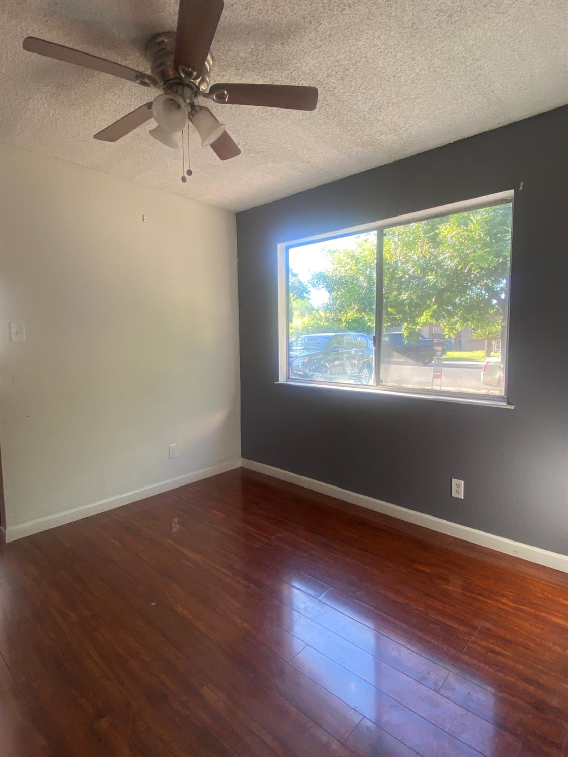 333 East Linden Avenue Reedley, CA 93654 - Photo 7 of 21 an empty room with wooden floor and windows