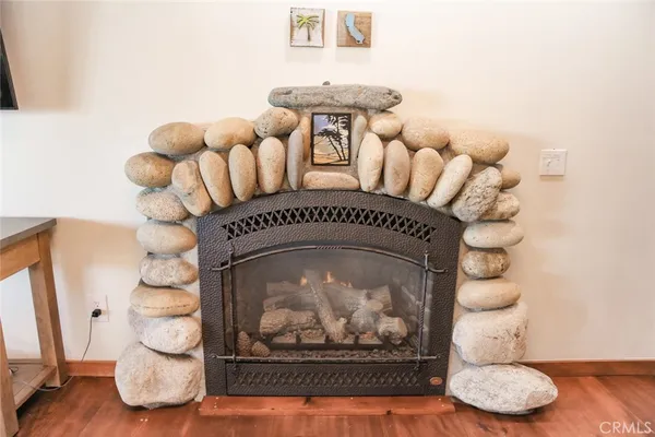 a living room with table a dining table wooden floor and a large window