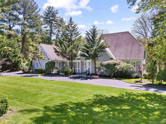 a view of a house with a yard and palm trees