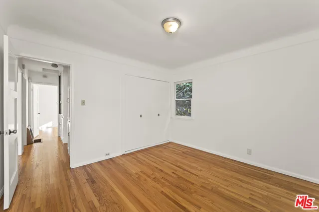 a view of a room with wooden floor and a window