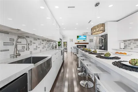 a large kitchen with stainless steel appliances lots of counter space and a sink