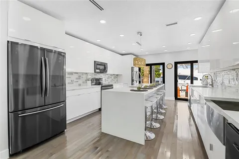 a kitchen with a refrigerator a sink and cabinets