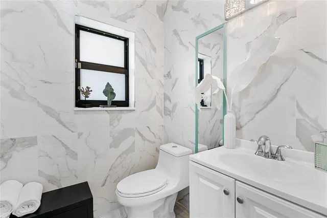 a bathroom with a toilet sink and mirror