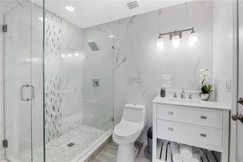 a bathroom with a sink a toilet and shower