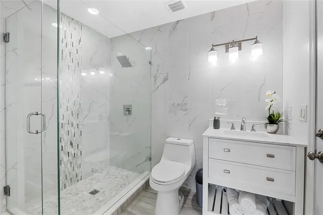 a bathroom with a sink a toilet and shower