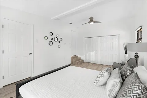 a bedroom with a white bed and a chandelier