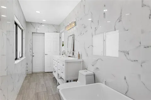 a large bathroom with a sink a toilet a shower and a mirror