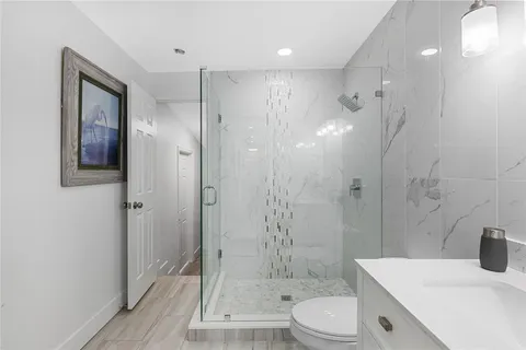 a bathroom with a sink a toilet and shower