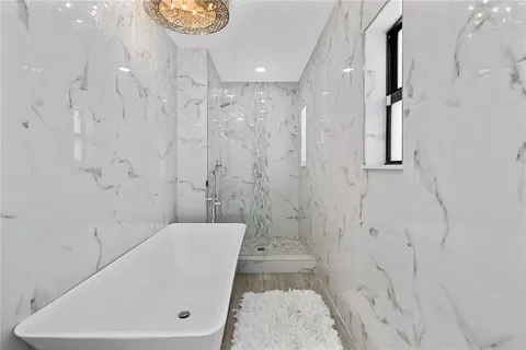 a bathroom with a tub a sink and a shower