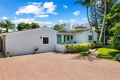 a front view of a house with a yard and potted plants