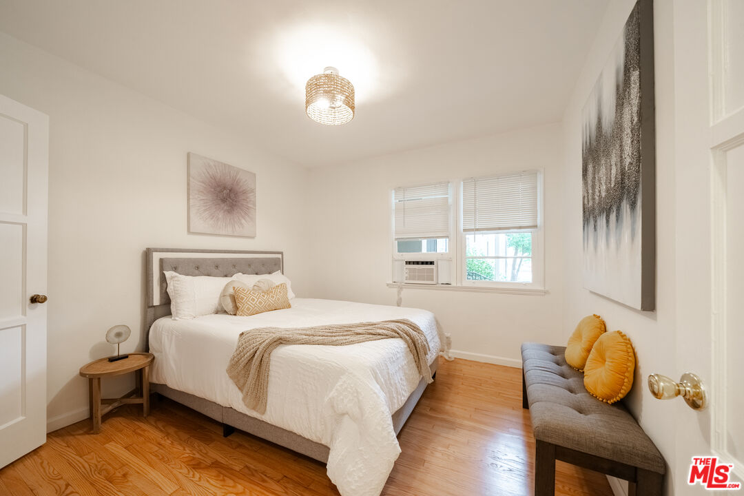 a bedroom with a bed and wooden floor