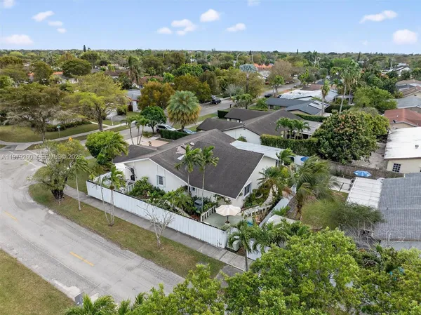 a view of a hallway with wooden floor and a kitchen