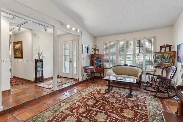 a bathroom with a granite countertop sink a toilet a mirror and shower