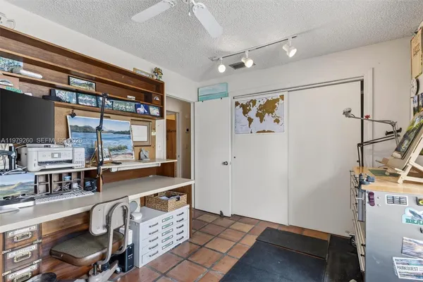 a large kitchen with granite countertop a large window and white cabinets