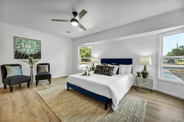 a bedroom with a bed a couch and a large window