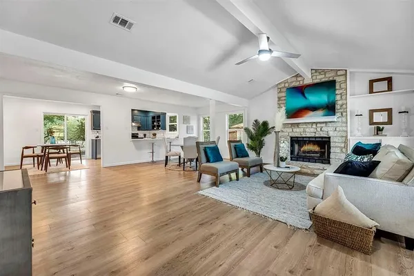 a living room with furniture a flat screen tv and a fireplace