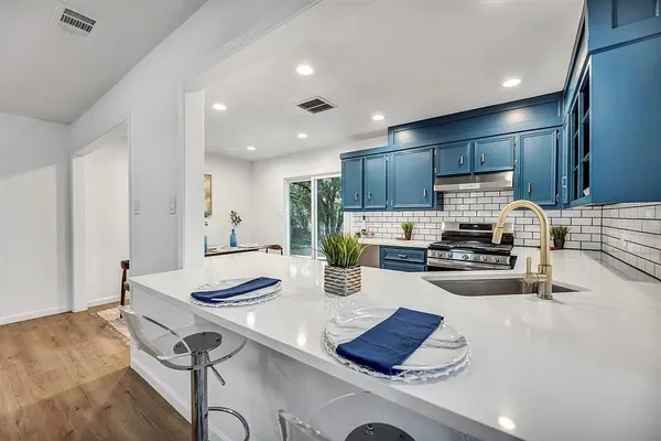 a kitchen with a sink appliances and cabinets