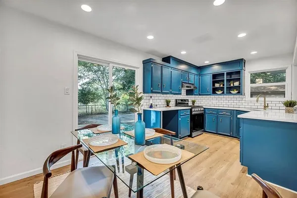 a kitchen with a table chairs microwave and cabinets