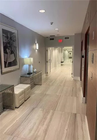 a view of a hallway with furniture and wooden floor