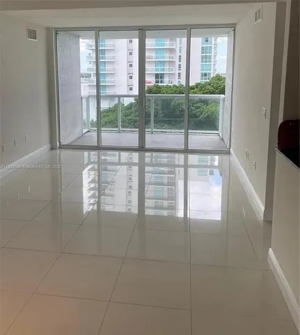 a view of a room that has a sliding door and wooden floor