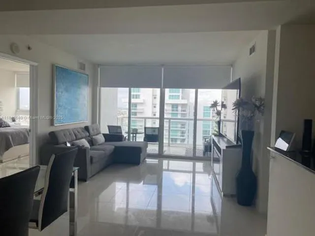 a living room with furniture and a floor to ceiling window