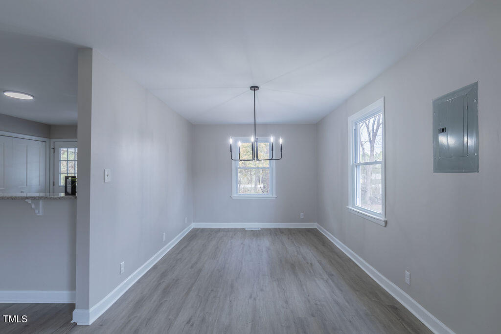 4814 Fayetteville Road Durham, NC 27713 - Photo 12 of 32 a view of an empty room with wooden floor and a window
