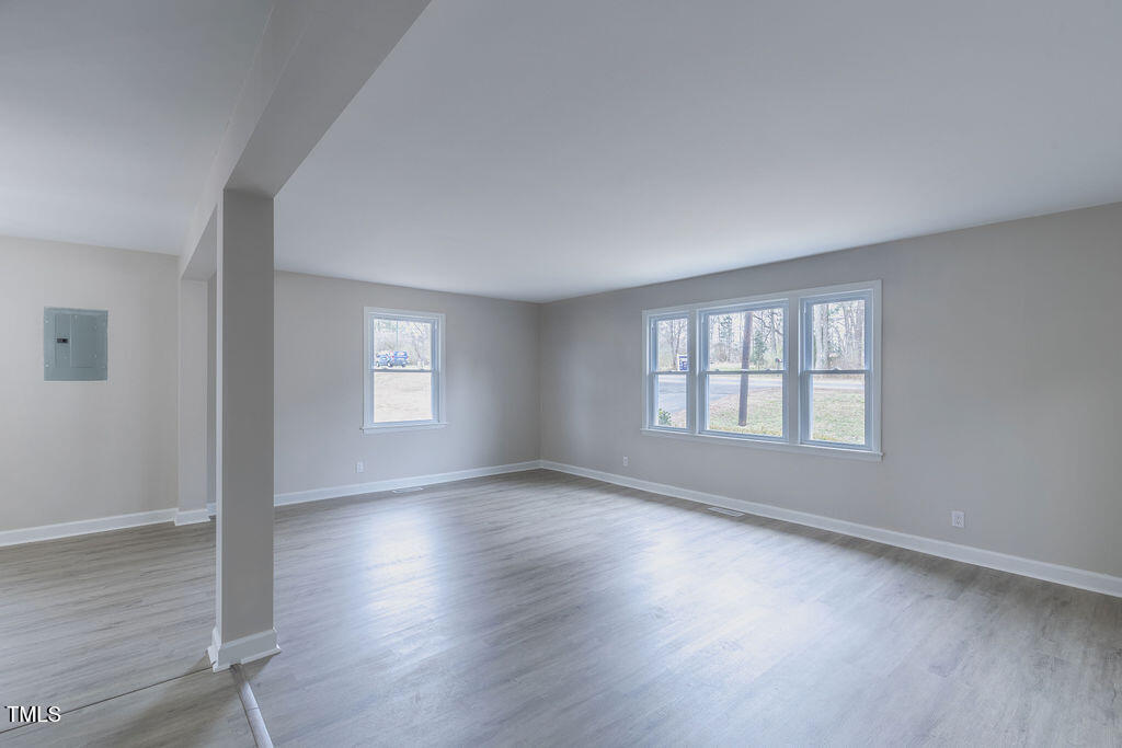 4814 Fayetteville Road Durham, NC 27713 - Photo 13 of 32 an empty room with wooden floor and windows