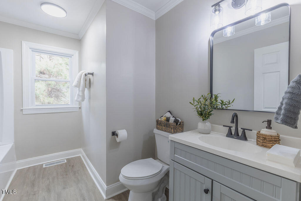 4814 Fayetteville Road Durham, NC 27713 - Photo 16 of 32 a bathroom with a sink a toilet a window and vanity